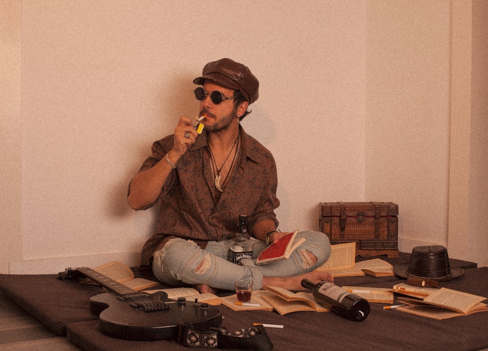 man in brown jacket and blue denim jeans sitting on brown wooden table