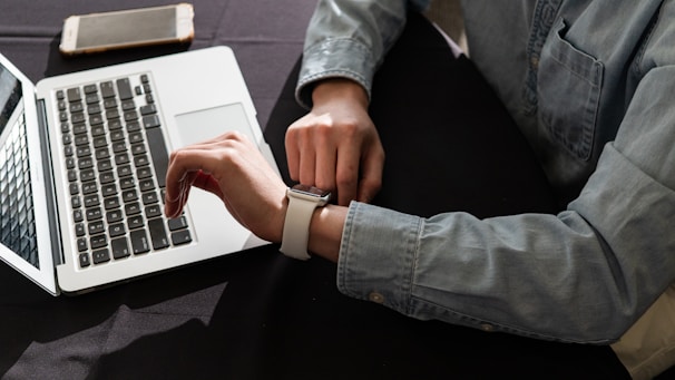 person in blue denim jacket using macbook pro