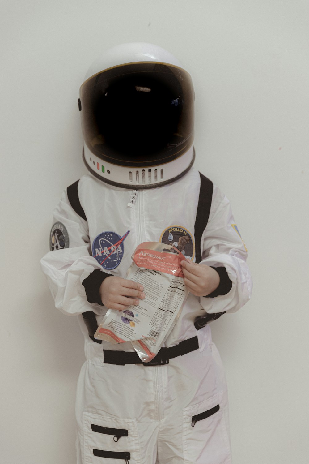 Un hombre con un traje espacial sosteniendo un periódico