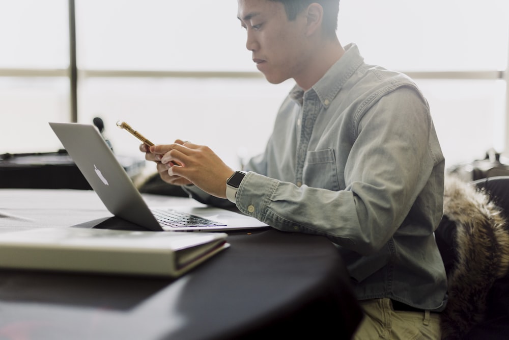 um homem sentado na frente de um computador portátil