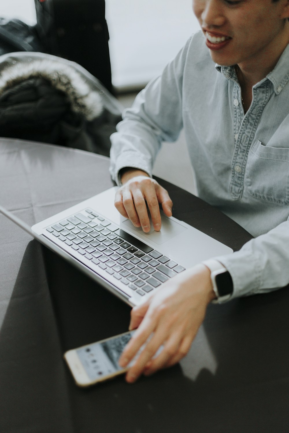 Ein Mann, der mit einem Laptop an einem Tisch sitzt