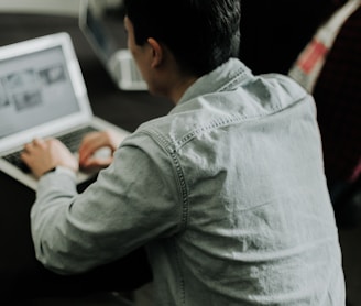 a man sitting in front of a laptop computer