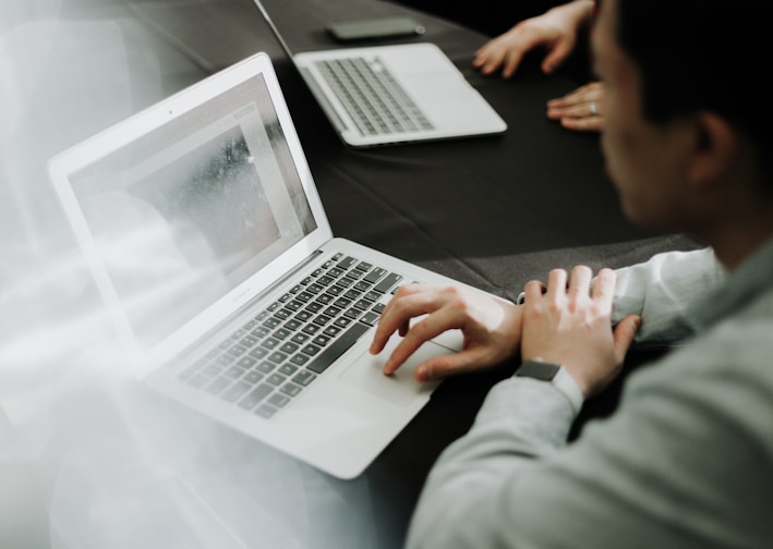 a man sitting in front of a laptop computer