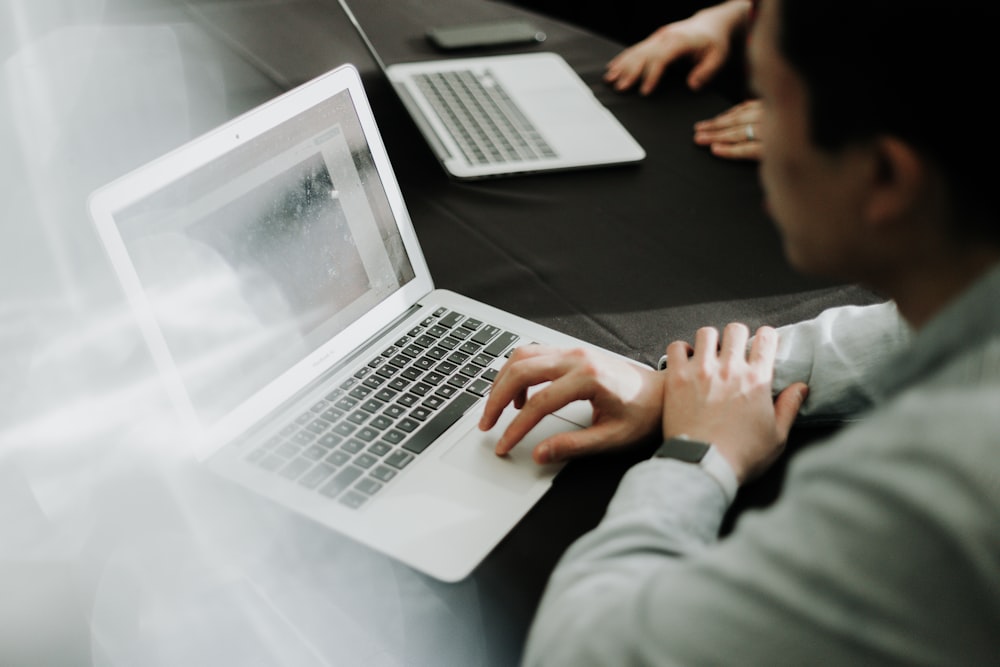 a man sitting in front of a laptop computer