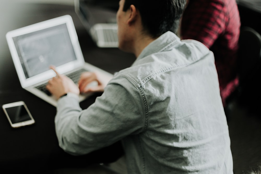 a man sitting at a table using a laptop computer