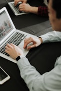 a man sitting at a table using a laptop computer