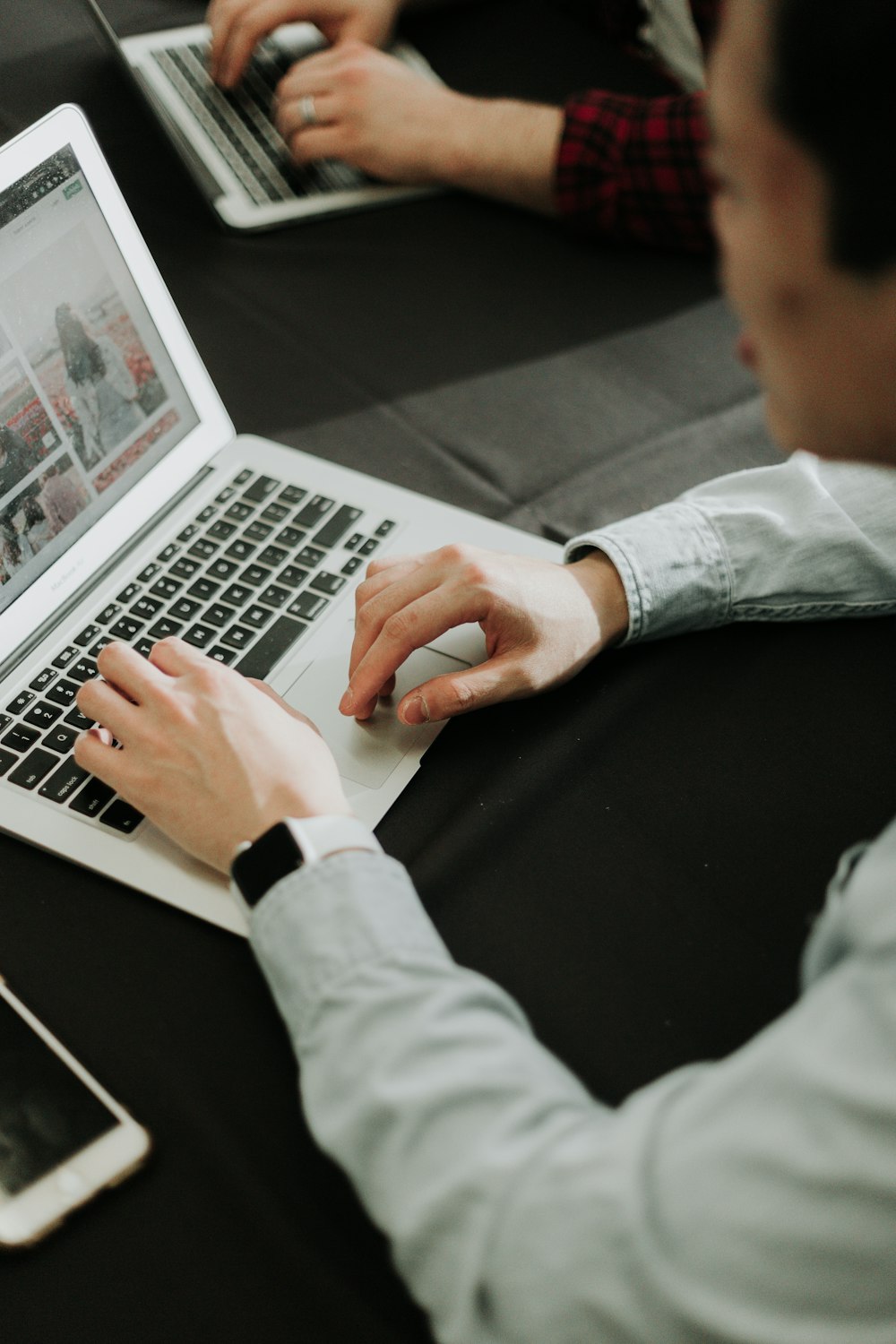 Ein Mann, der mit einem Laptop an einem Tisch sitzt