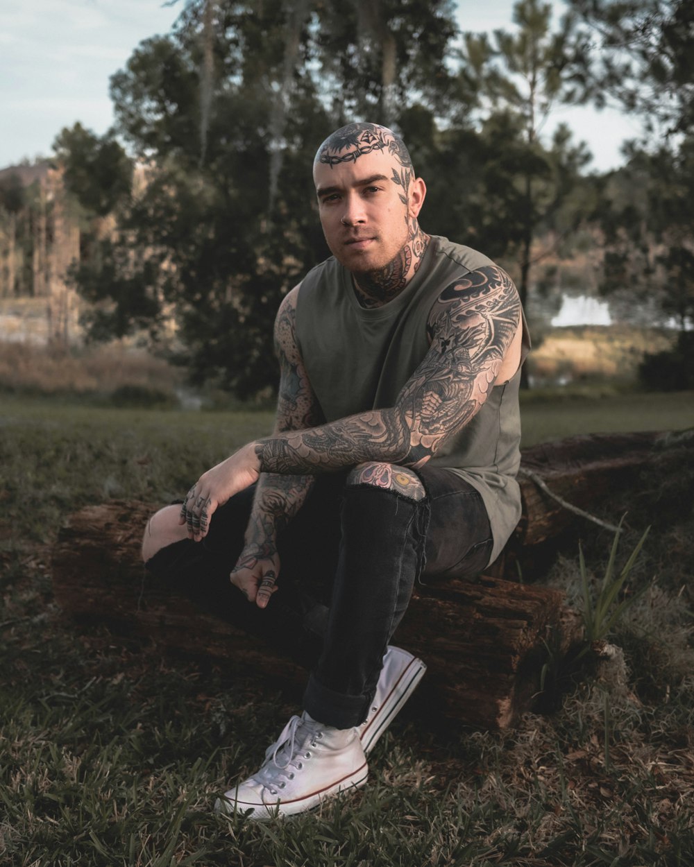 man in brown long sleeve shirt and black pants sitting on brown log