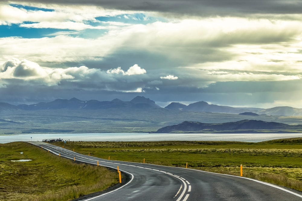 an empty road with mountains in the background