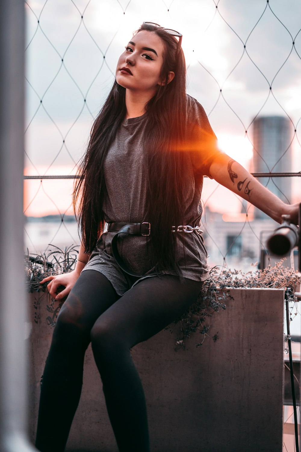 a woman with long hair sitting on a ledge