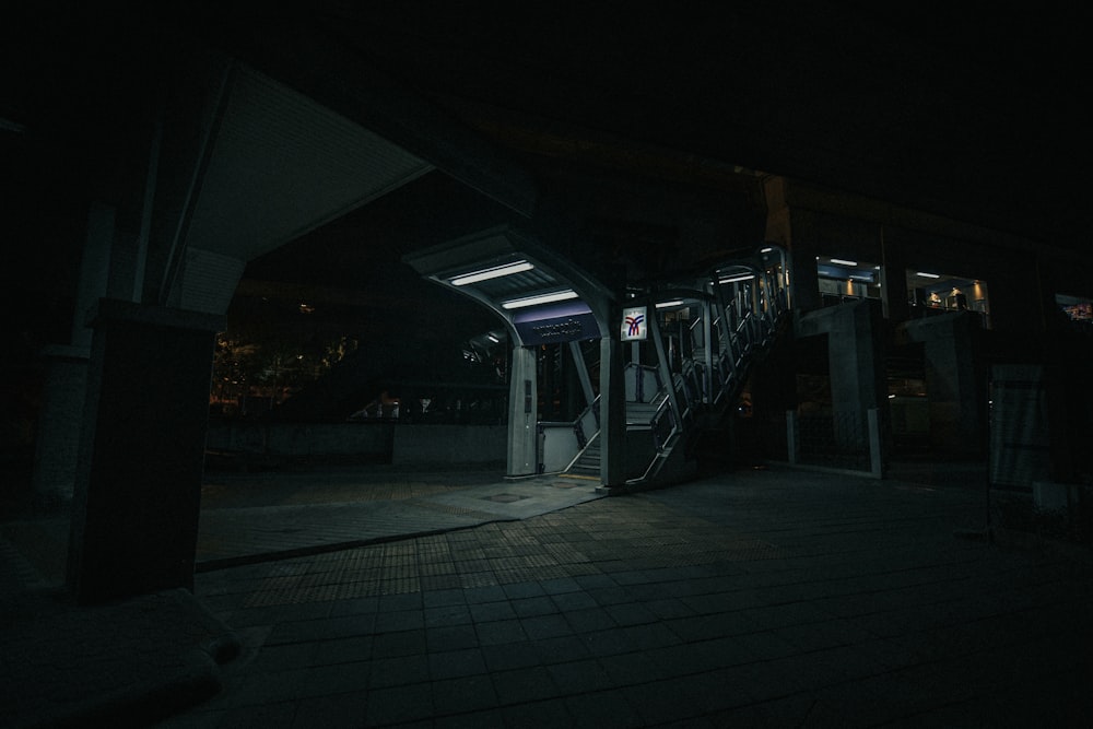 a train station at night with the lights on