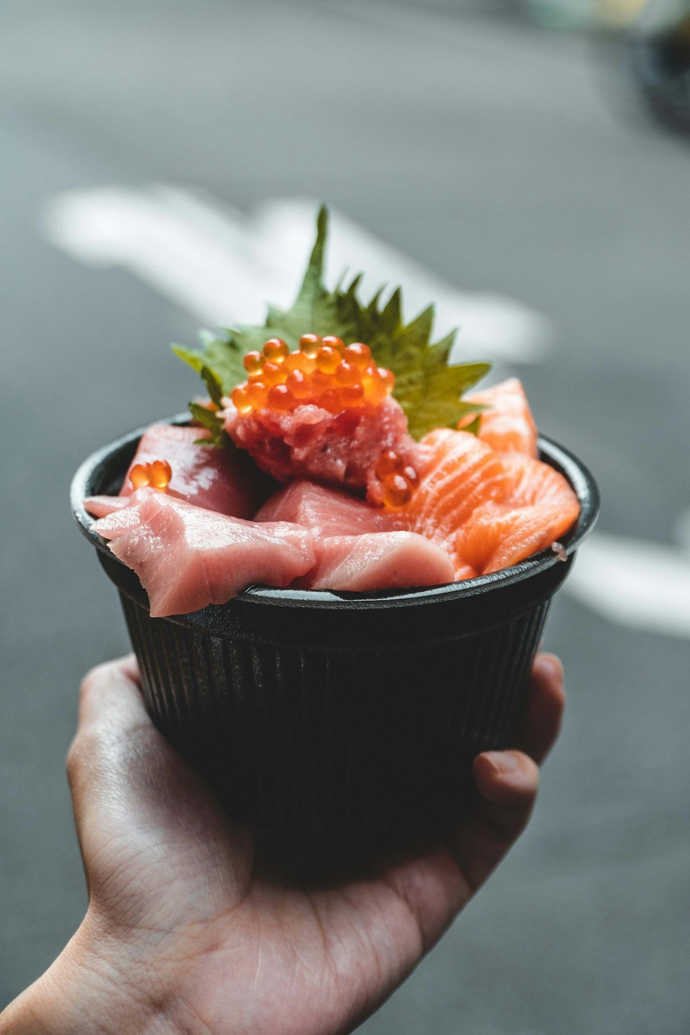 a person holding a small bowl of food