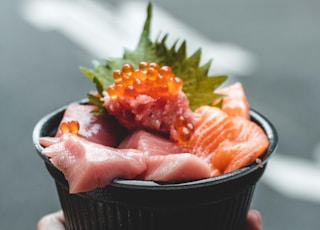 a person holding a small bowl of food