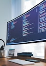 a computer monitor sitting on top of a wooden desk