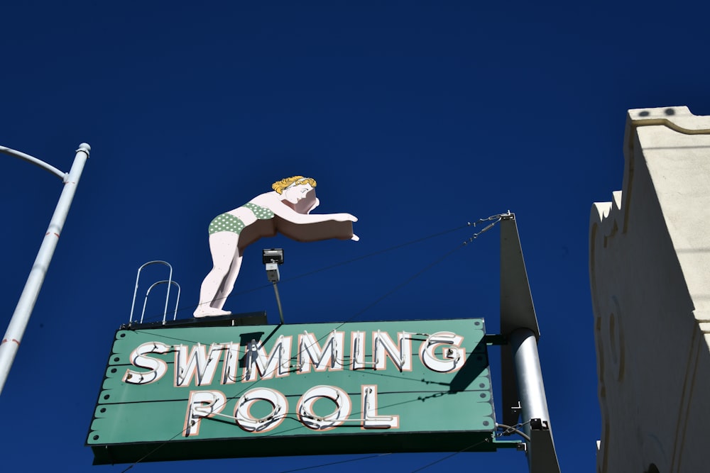 a swimming pool sign hanging off the side of a building