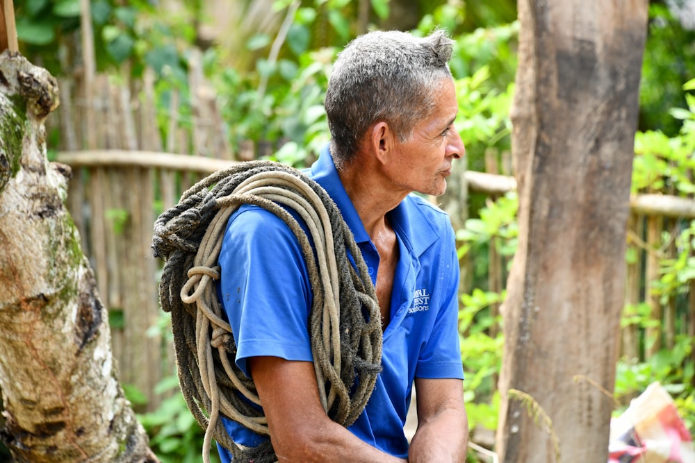 a man in a blue shirt holding a rope