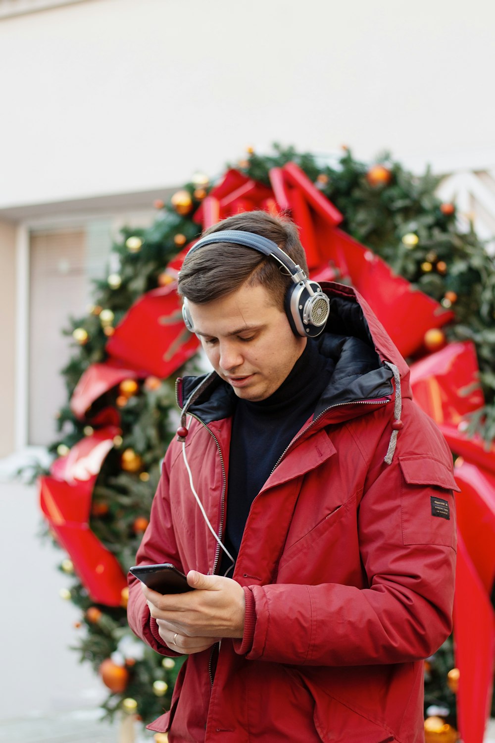 a man in a red jacket listening to headphones