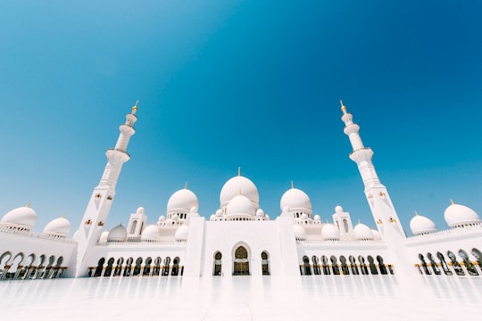 white and brown mosque under blue sky during daytime in Sheikh Zayed Mosque United Arab Emirates
