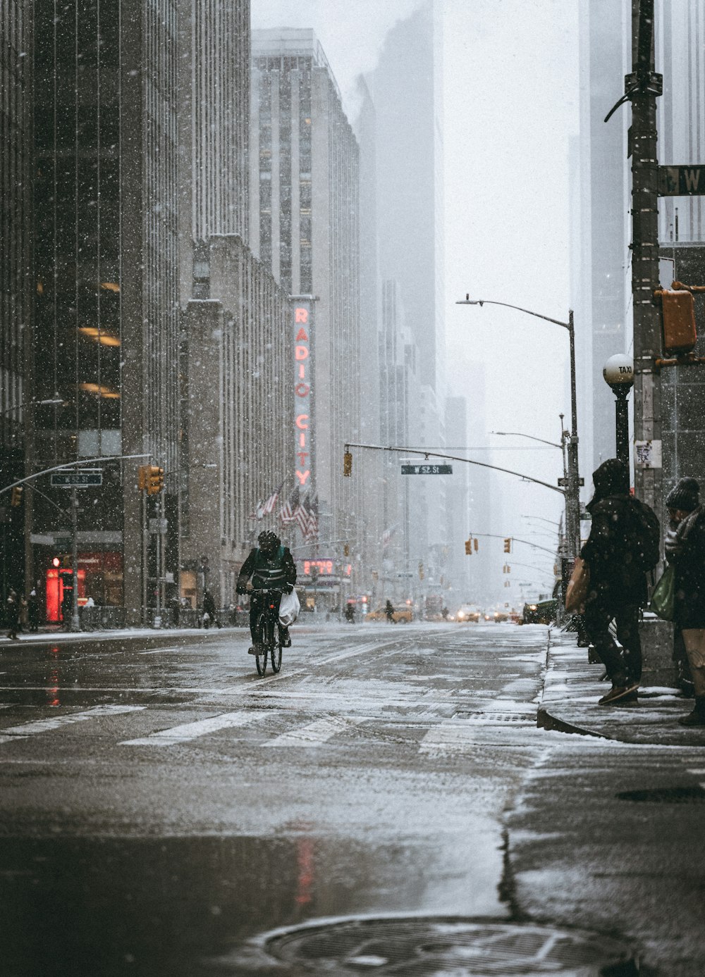 a man riding a motorcycle down a rain soaked street