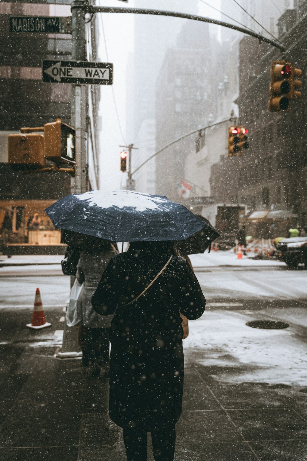 a woman walking down a street holding an umbrella