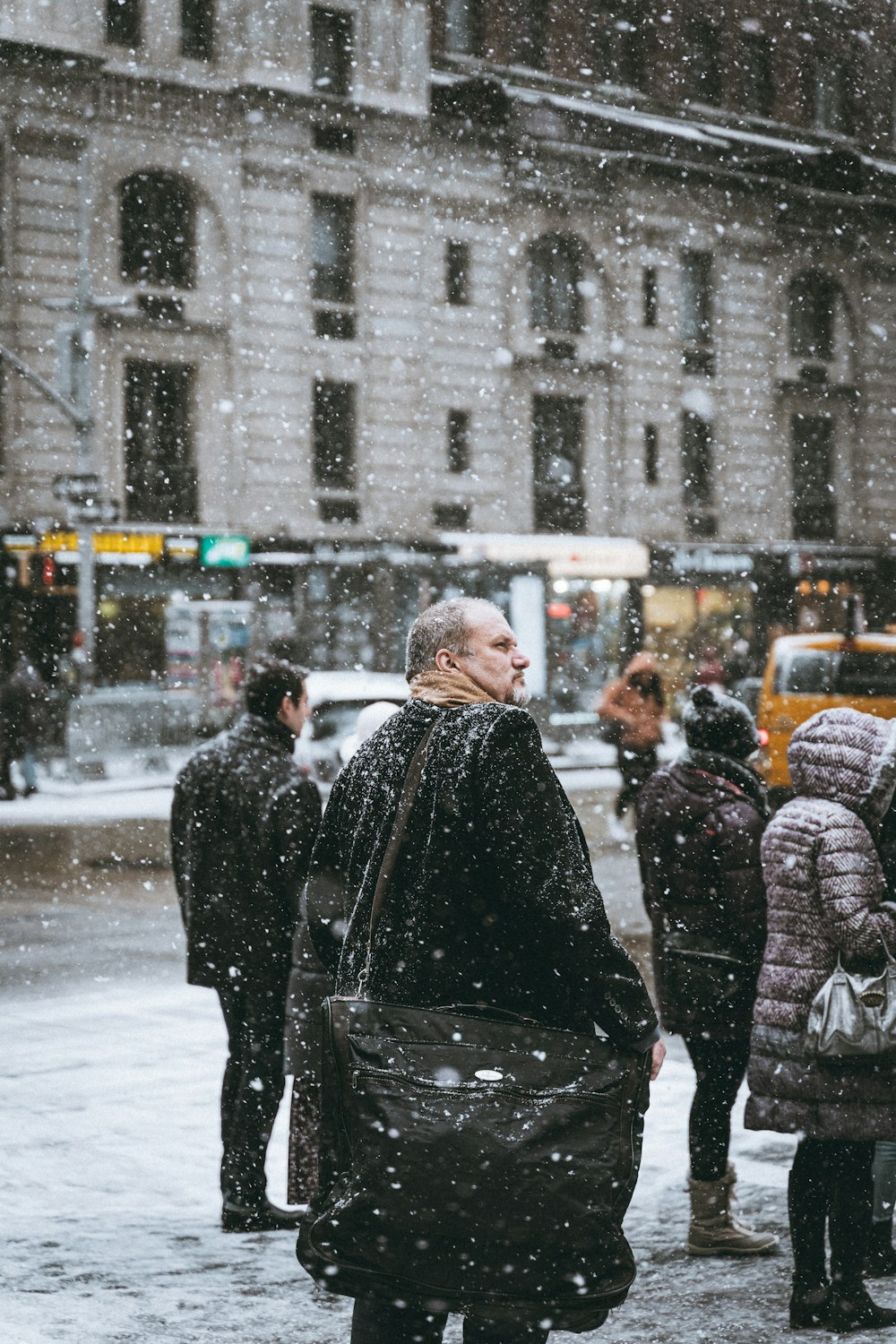 a group of people walking down a snow covered street