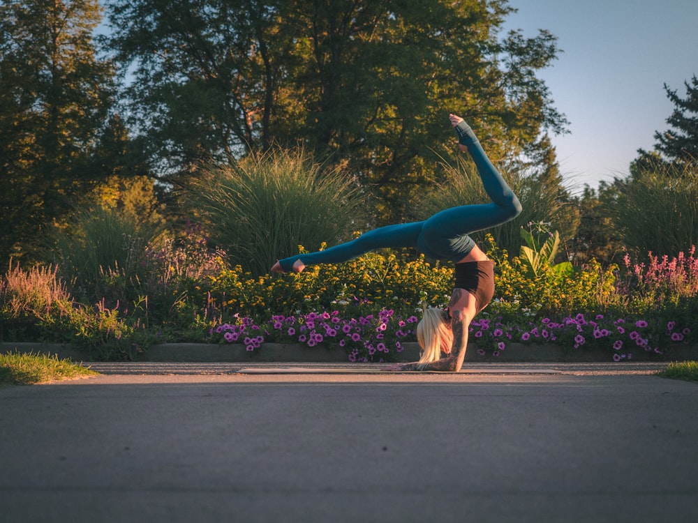 a woman doing a handstand in a park