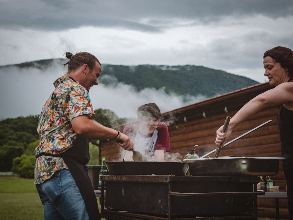 un groupe de personnes cuisinant sur un gril à l’extérieur