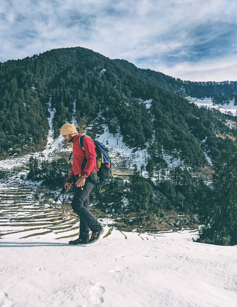 a man with a backpack hiking up a snowy mountain