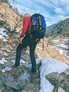 a person with a backpack is hiking up a snowy hill