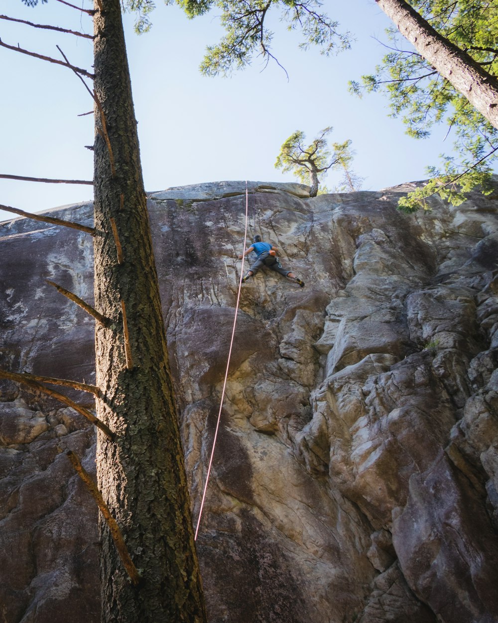 a man climbing up the side of a mountain