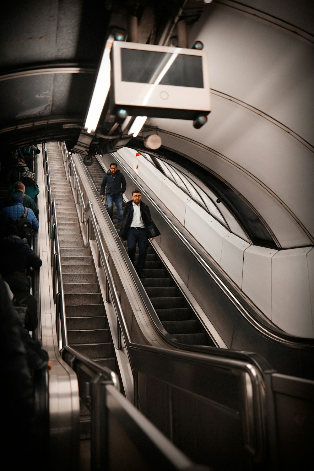 a group of people riding down an escalator