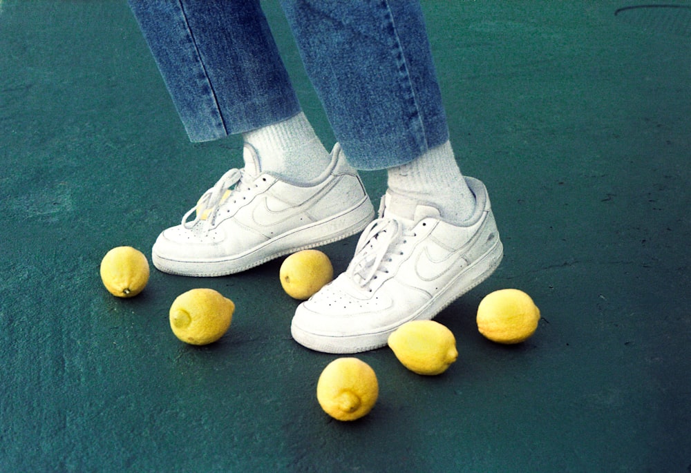a person standing on a tennis court with tennis balls