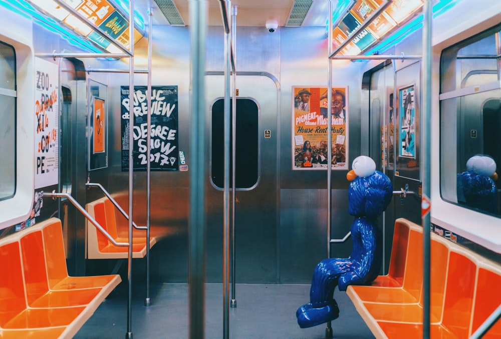 a subway car with orange seats and graffiti on the walls