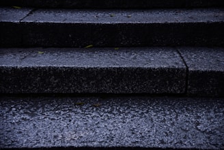 Outdoor concrete entry steps with anti-slip treatment on a rainy day.
