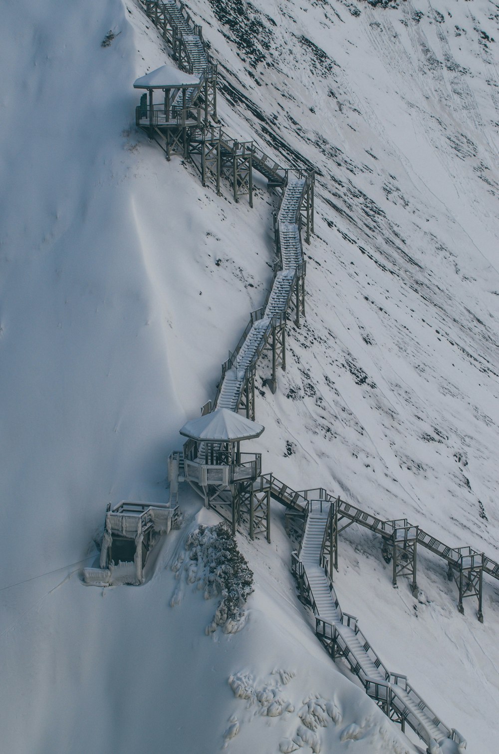 a snow covered hill with a wooden structure on top of it