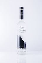 A vodka bottle featuring a sleek design with a black and white grand piano image. The label includes text in an elegant font and highlights the name 'OGINSKI VODKA'. The bottle is clear and sits against a plain, light background.