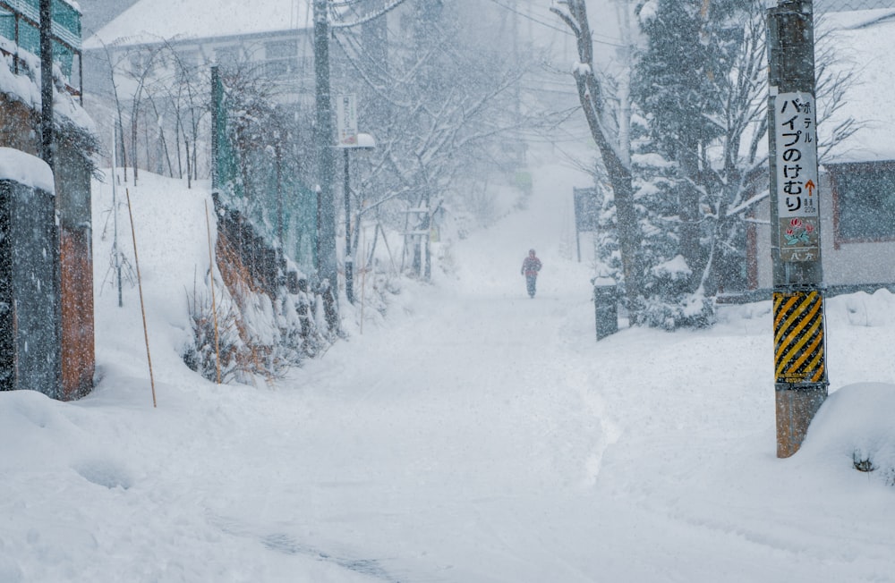 eine Person, die eine schneebedeckte Straße entlang geht