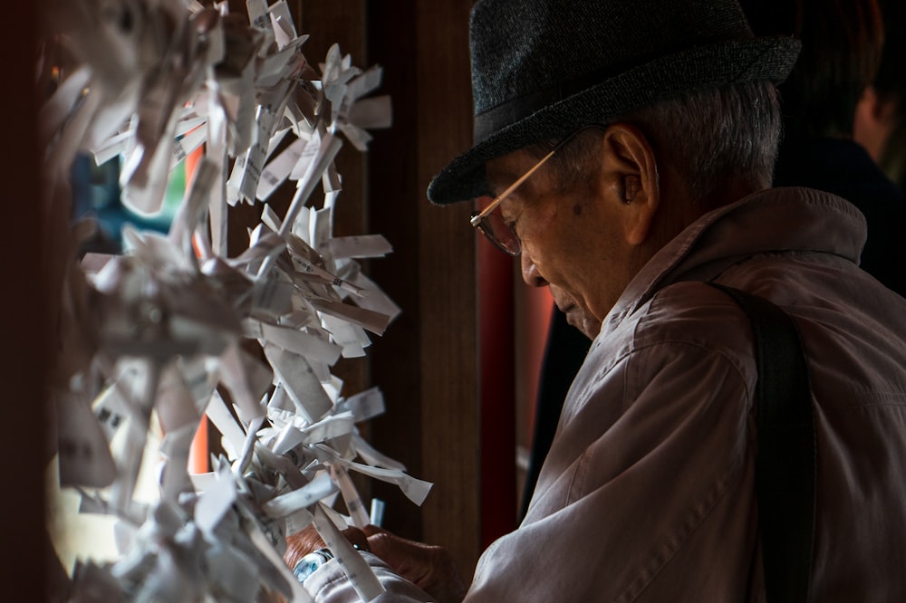 a man looking at a bunch of paper cranes