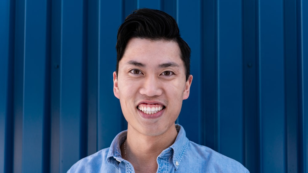 man in blue button up shirt smiling