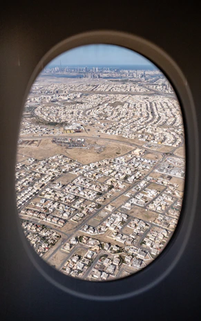 An aerial shot of a bustling cityscape taken from a plane mid-flight.