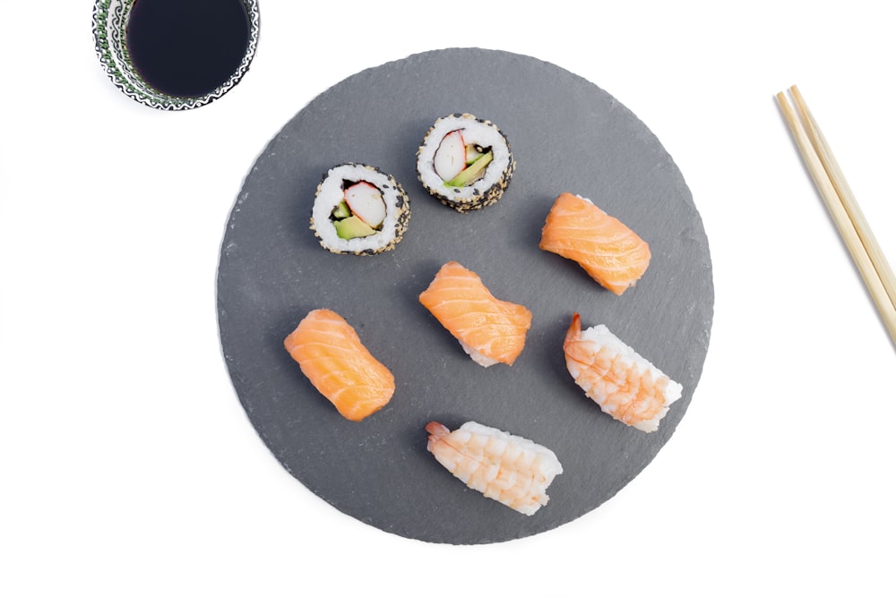 um prato com sushi e pauzinhos