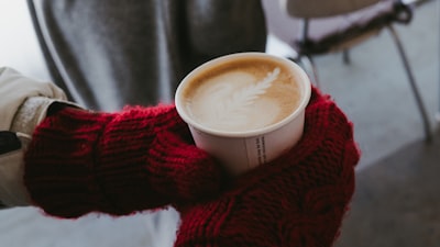 white ceramic mug on red knit textile mittens google meet background