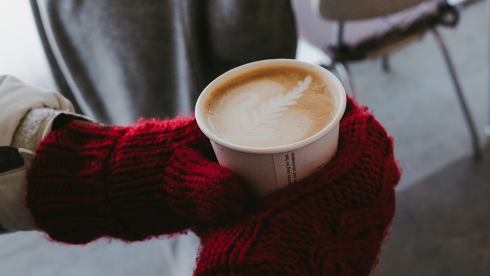 white ceramic mug on red knit textile