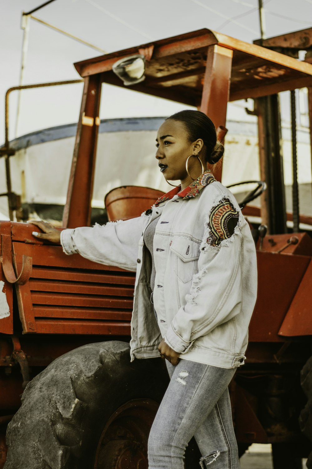 a woman standing in front of a tractor