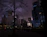 Urban night cityscape background with sleek dark mode design accents in lavender and gray.