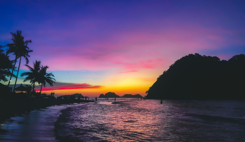 silhouette of people on beach during sunset