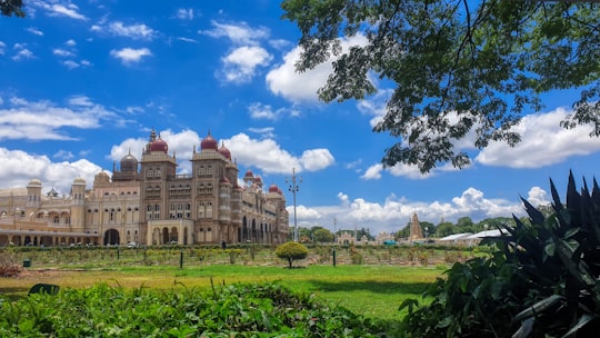brown and white concrete building under blue sky during daytime in Mysore Palace India