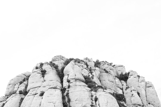 gray rock formation under white sky during daytime in Montserrat Spain