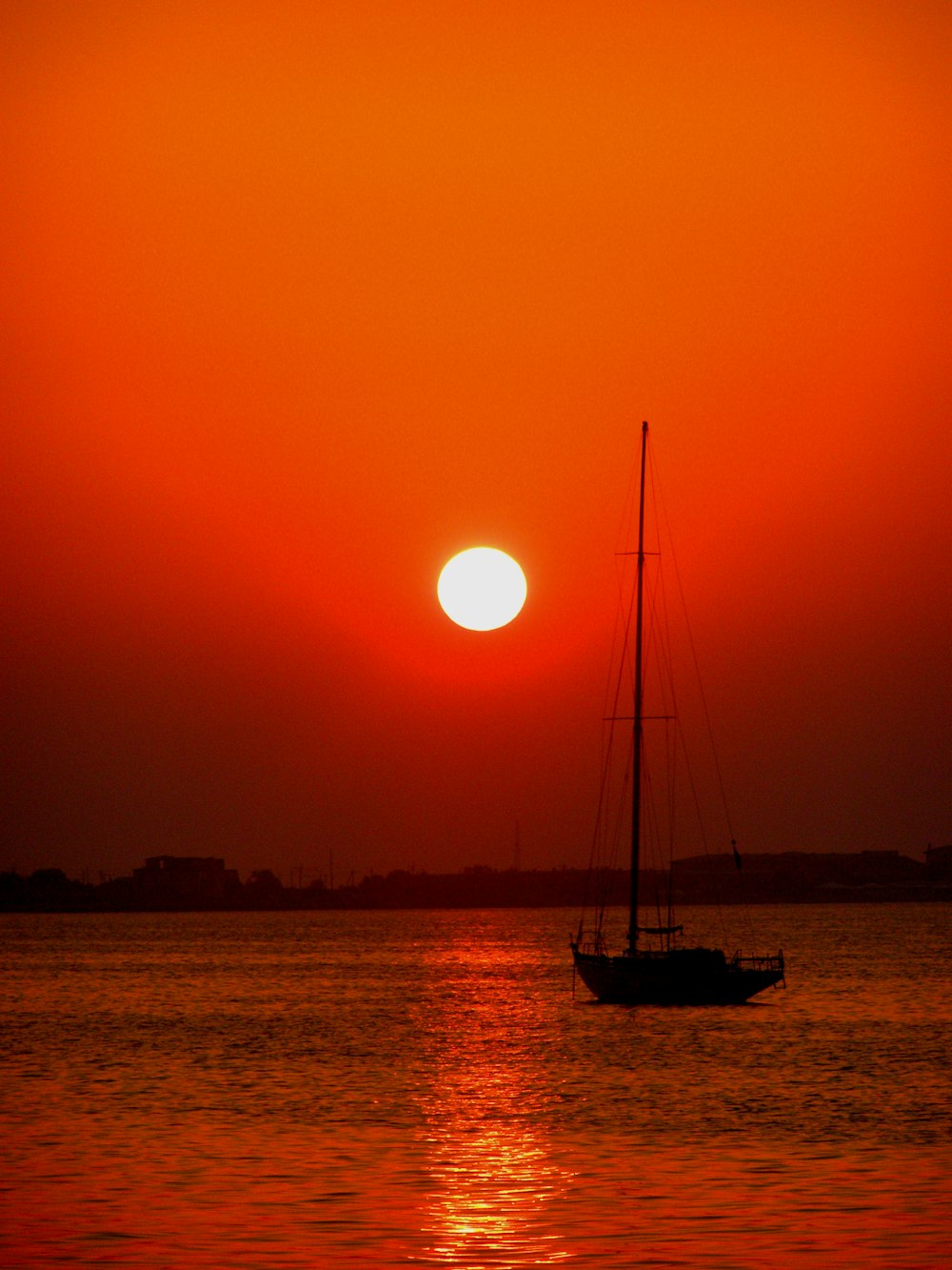 a sailboat in the water at sunset