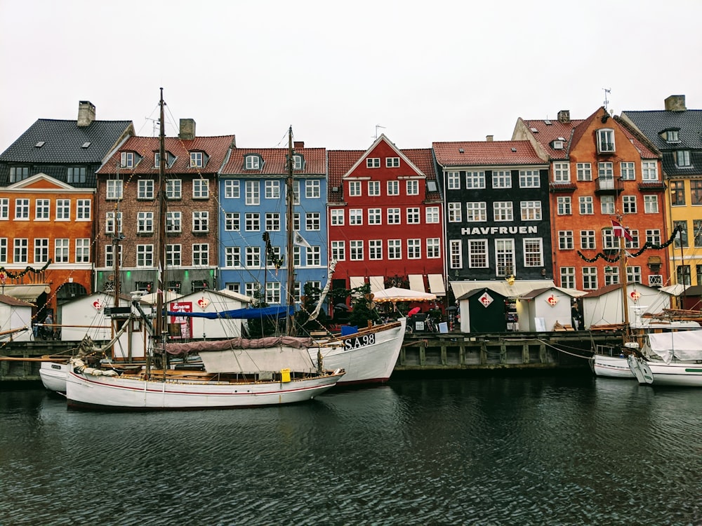 white boat on body of water near buildings during daytime